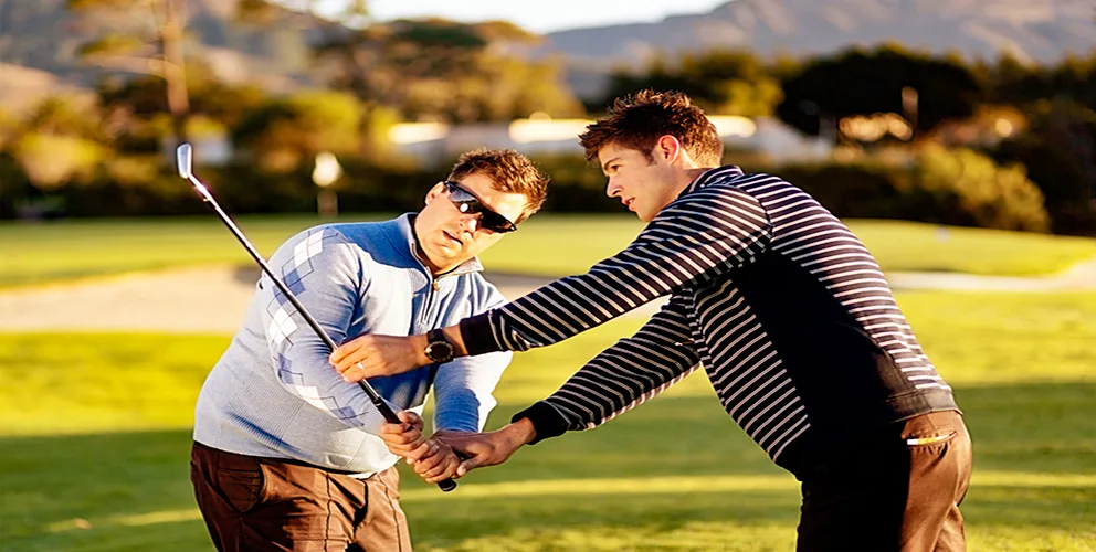 A golf Pro teaching a golf swing to a guy