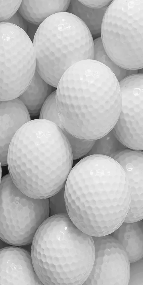 Black and white image of golfball pile close up.