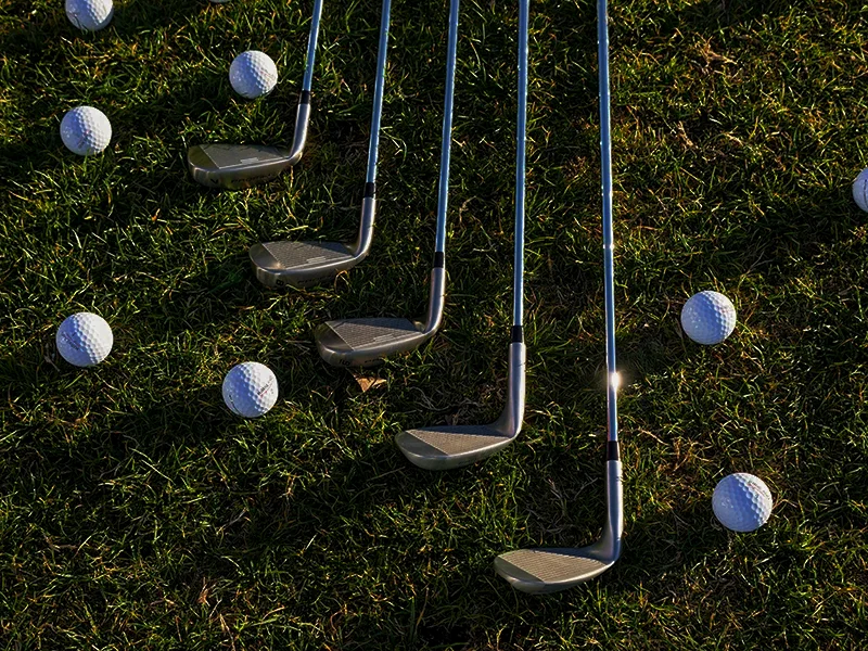 Golfclubs and Balls laying on the grass